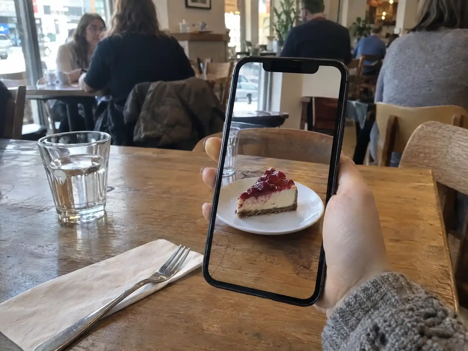 Un client pose une part de cheesecake en réalité augmentée sur sa table de restaurant depuis son smartphone